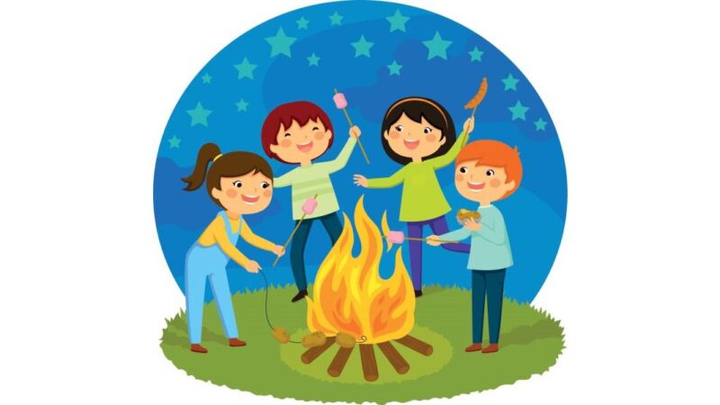 Happy kids having a bonfire roasting marshmallows and potatoes.