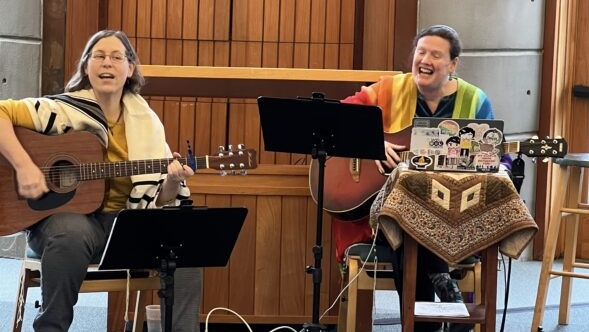 Rabbis Jarah & Rachel singing & playing guitar at Jewish Journeys Shabbat.
